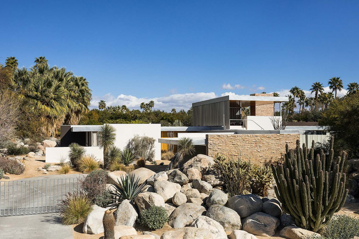 Kaufmann Desert House in Palm Springs viewed from driveway with desert landscaping and blue sky